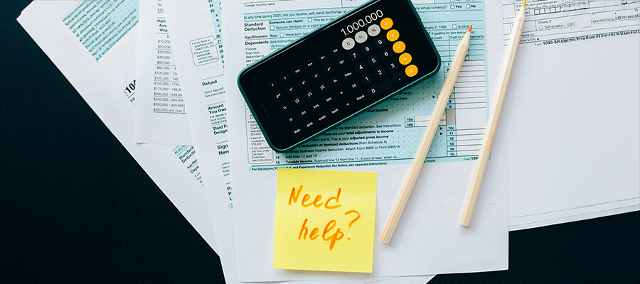 Calculator showing 1,000,000 and a post it with 'Need Help' written on it.