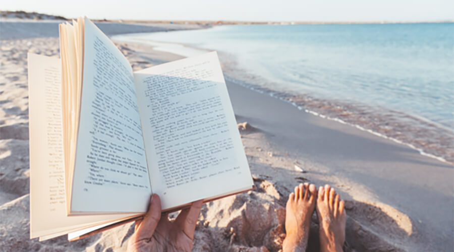 Close up of an open book on the beach.