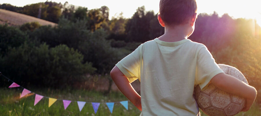 Boy with a ball in the countryside.