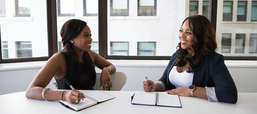 Young businesswomen with notebooks in an office.