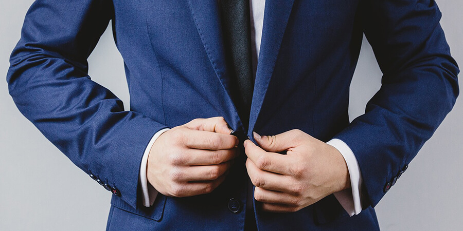 Businessman buttoning his suit jacket.