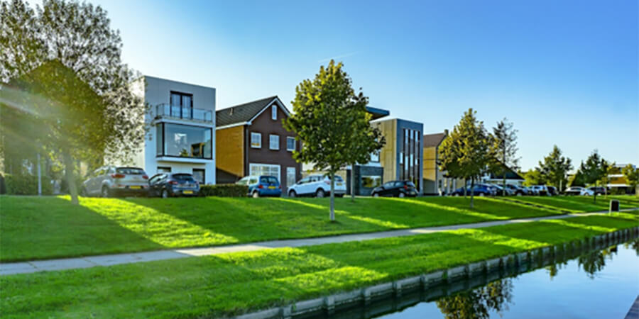 A row of modern houses along the side of a canal.