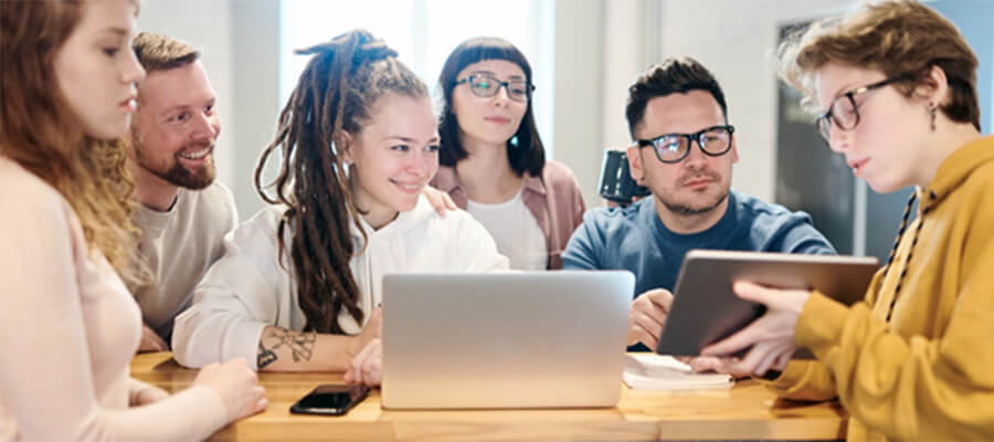 Group of happy young professionals looking at a tablet.