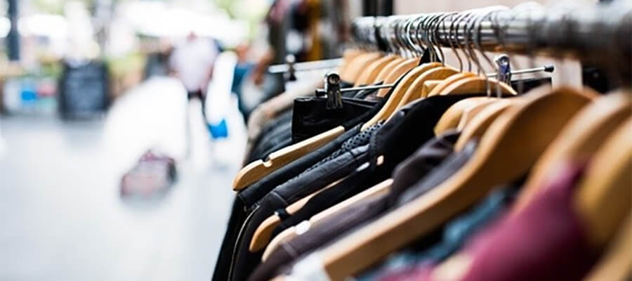 A rail of clothes on coat hangers.