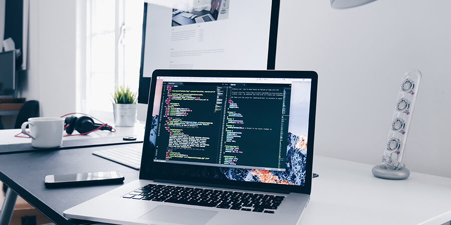 Laptop with code on a modern desk.