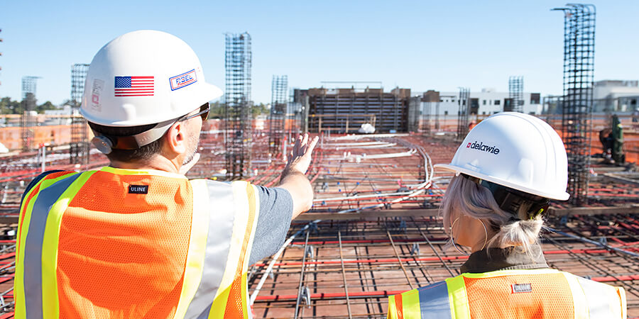 Construction workers looking over a large construction site.