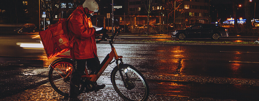 Bike courier on a wet night in the city.