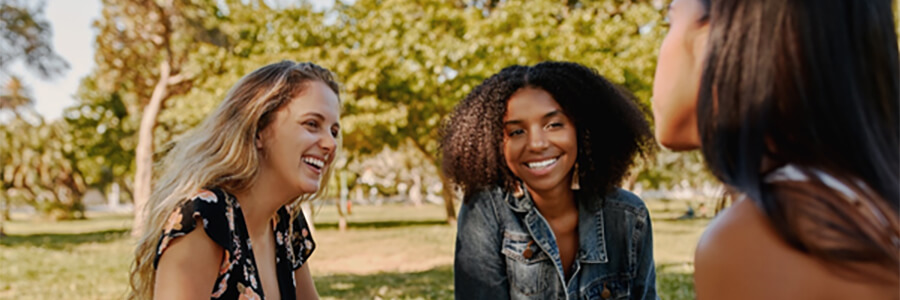 Three women from different cultures communicating.