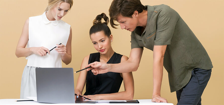 Young professionals looking at a laptop screen.