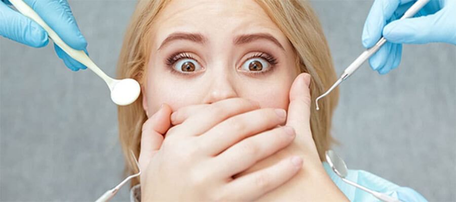 Scared woman with dental implements