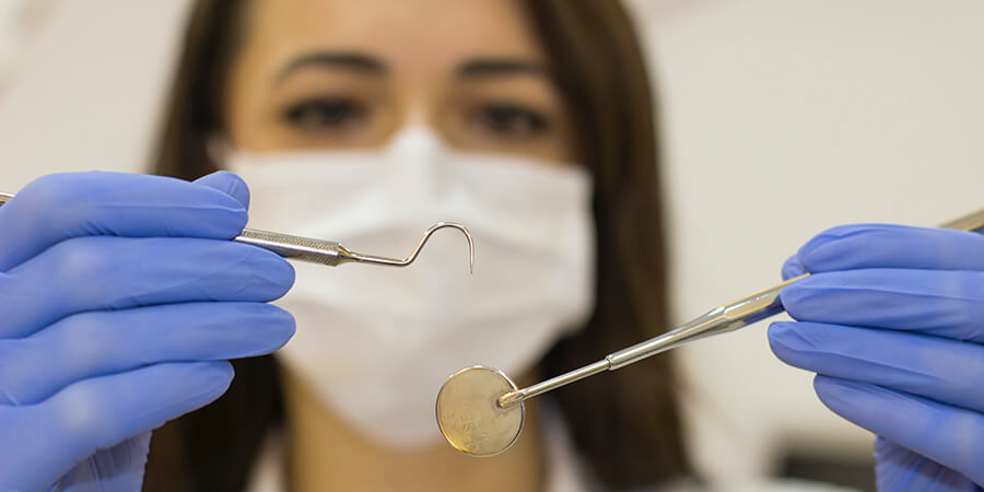 Female dentist with dental tools.