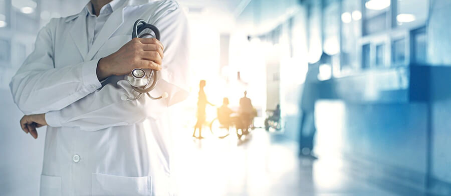 Montage medical images, torso of a doctor, wheelchair in a hospital corridor.