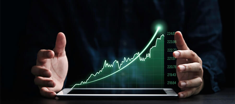 A graph showing a positive trend projected from a tablet, between two hands.