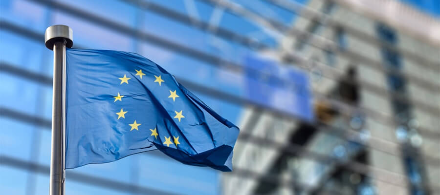 EU flag flying in front of building.