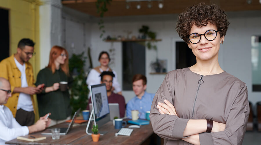 Striking woman with glasses smiling in an office.