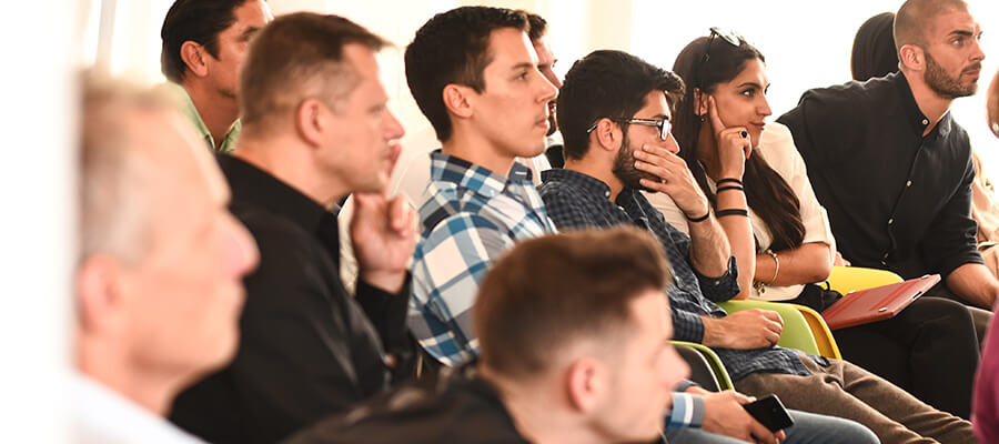 Group of people watching and listening to a presentation.