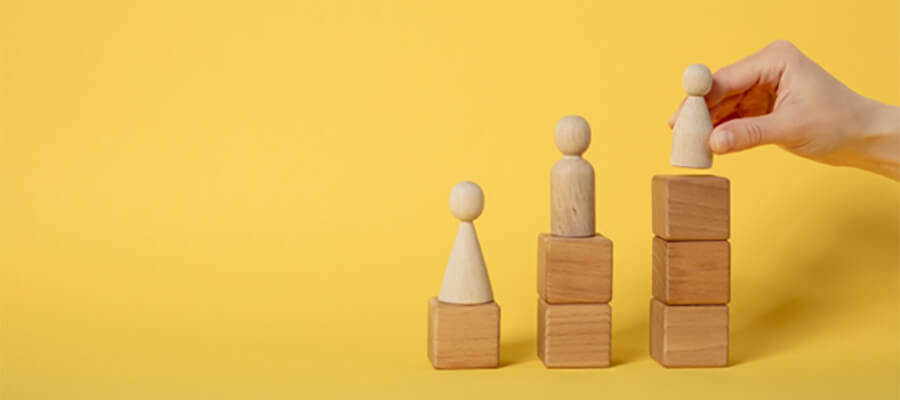 Wooden figures on higher wooden blocks.