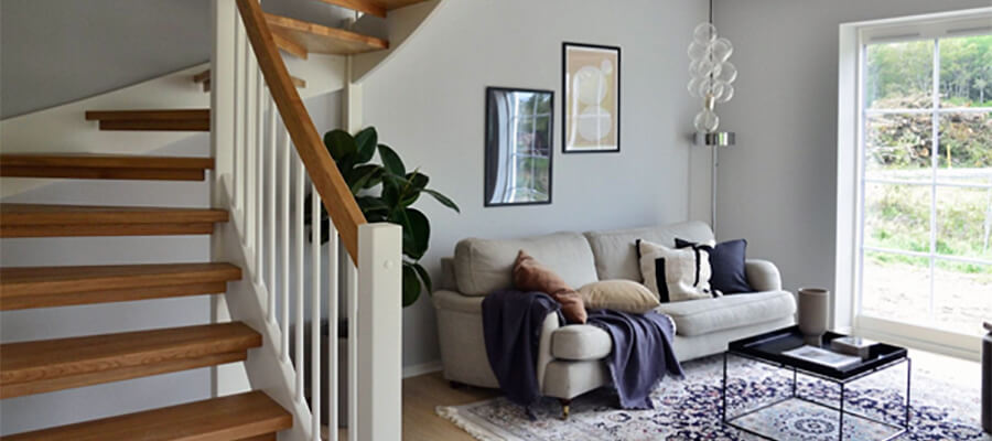 House interior with sweeping staircase and sofa.