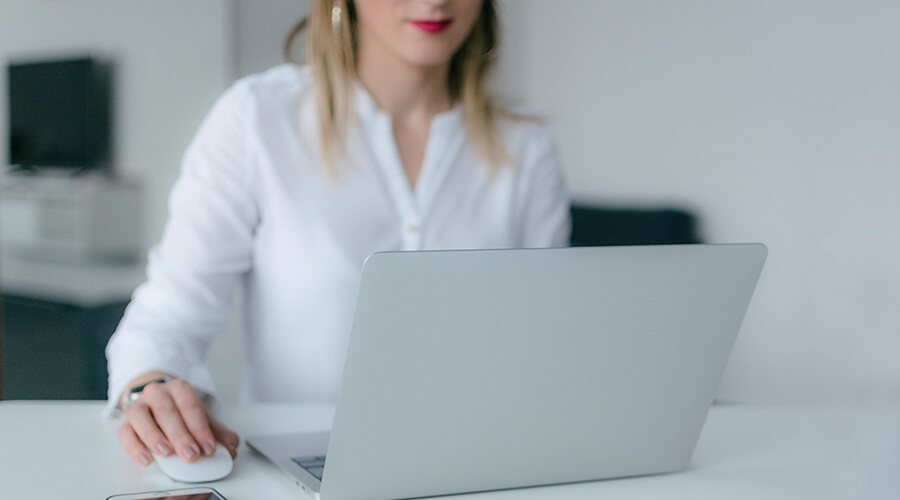 Woman with red lips and white shirt using a laptop.