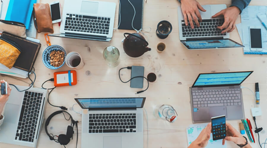 A table full of laptops and phones.