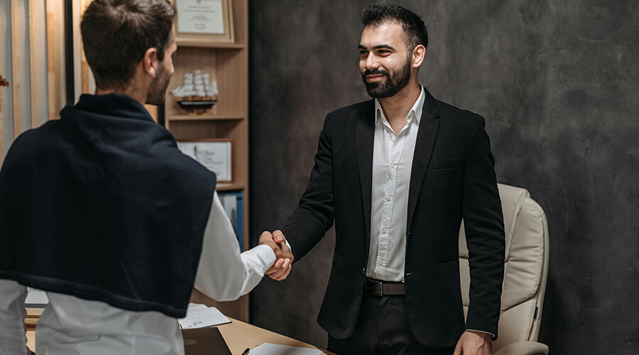 Two smartly dressed men shaking hands.