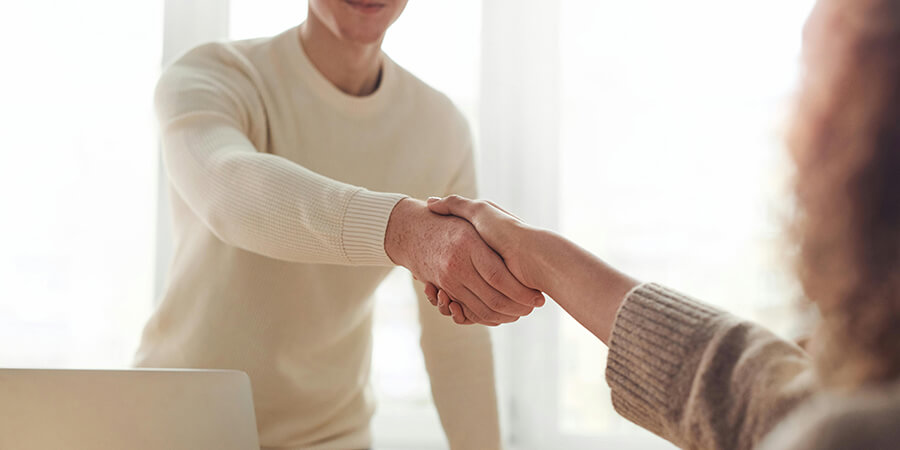 Handshake over a table.