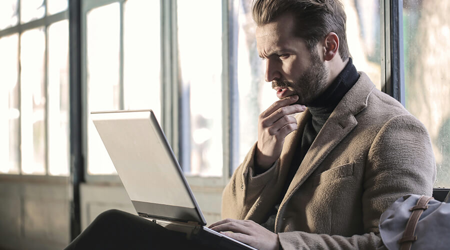 Man looking intently at a laptop.