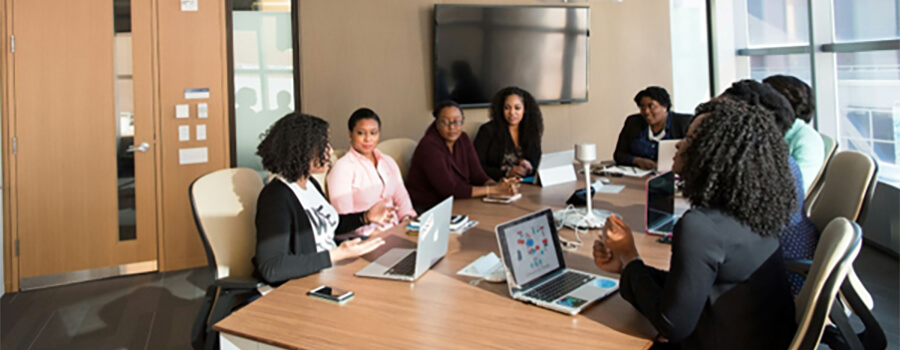 Group of people sitting around a large table for a meeting.