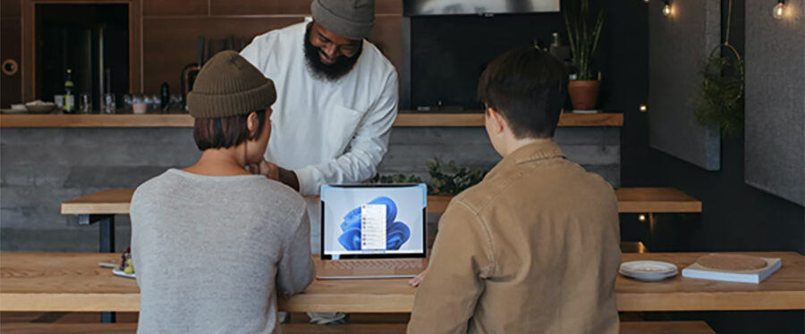 Two people looking at a Windows 11 computer in a modern restaurant