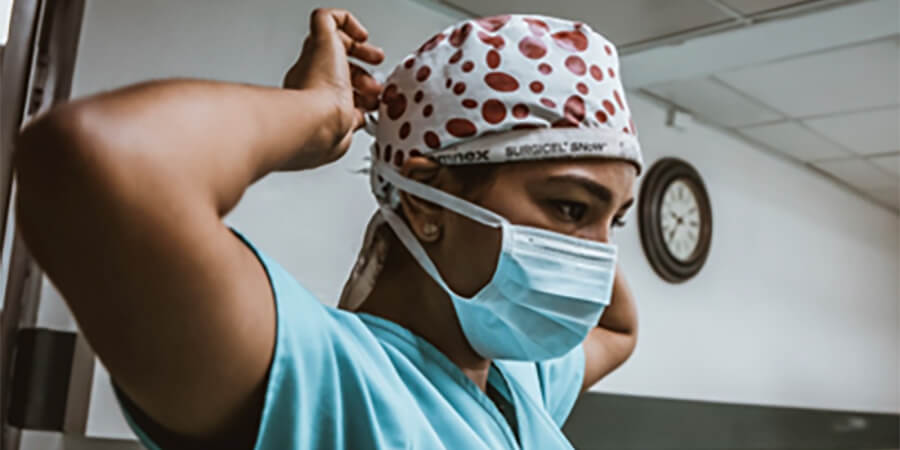 Nurse putting on her head scarf.