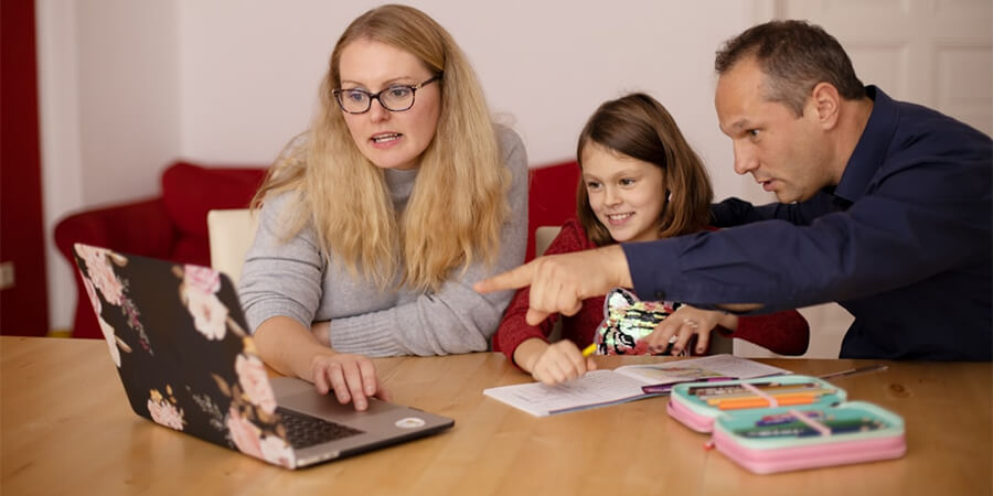 Parents helping their daughter with homework