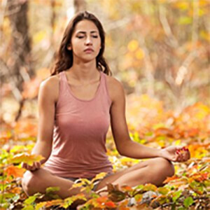 Woman meditating in a forest