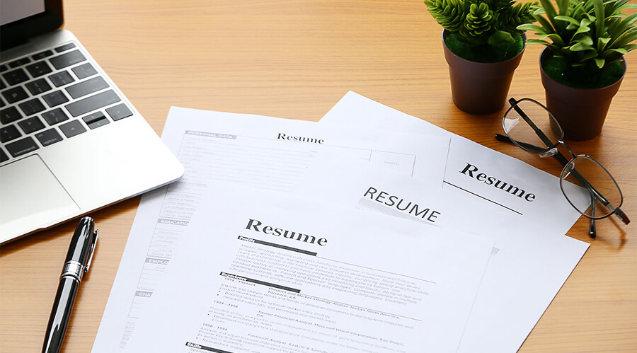 Printed resumes on a desk.