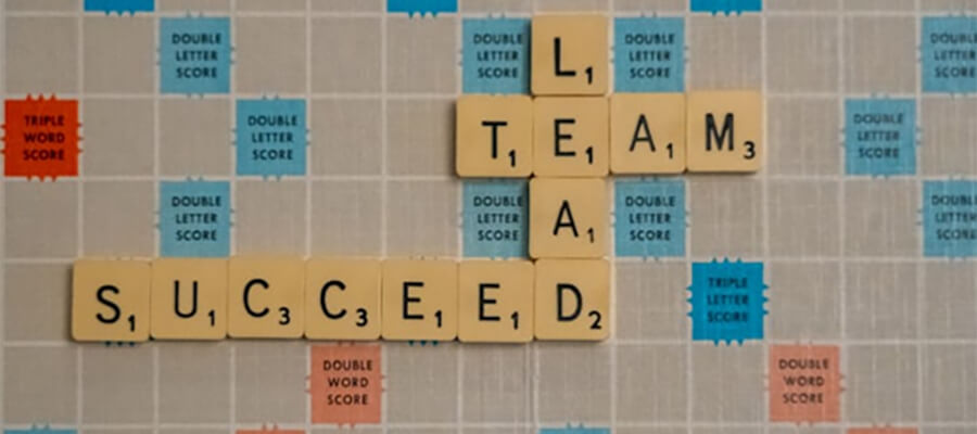 'LEAD, TEAM, SUCCEED' spelt out on a scabble board.