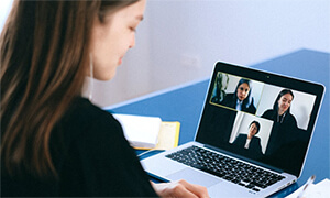 Woman communicating via Zoom on a laptop.