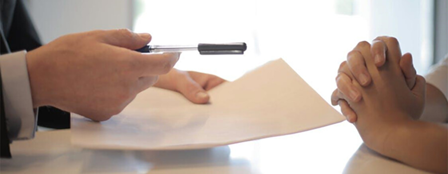 Businessman giving contract to woman to sign.