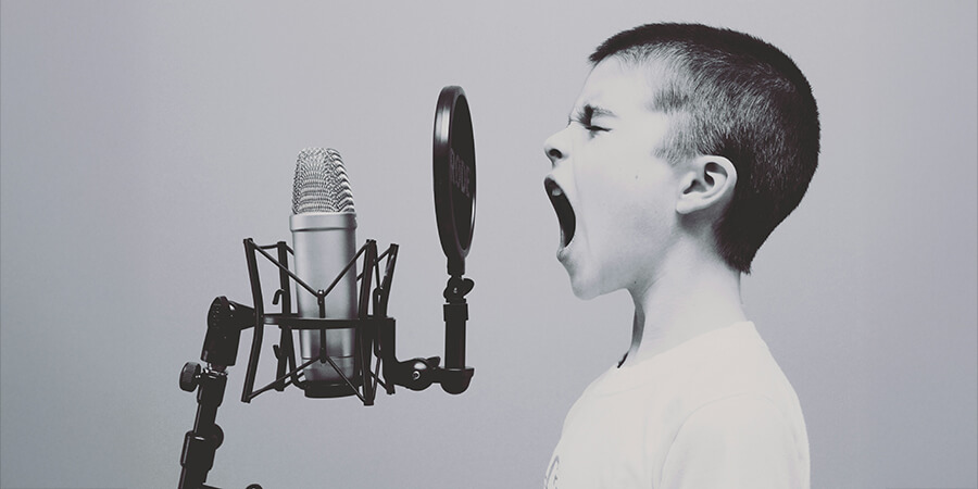 Young person singing into a microphone.