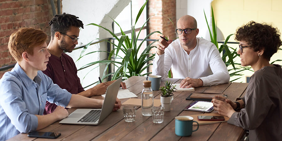 Four people in a modern team meeting.