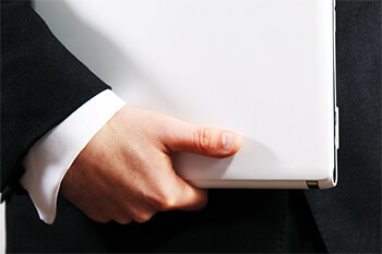 Man in suit carrying a laptop.