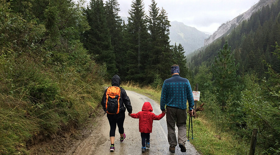 Parents walking on a forrest track with thewir child.