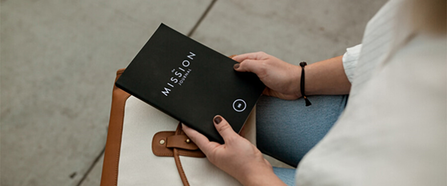 Woman with book called 'Mission'