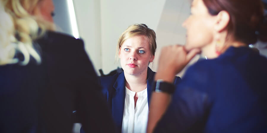 Woman in interview looking reflective.