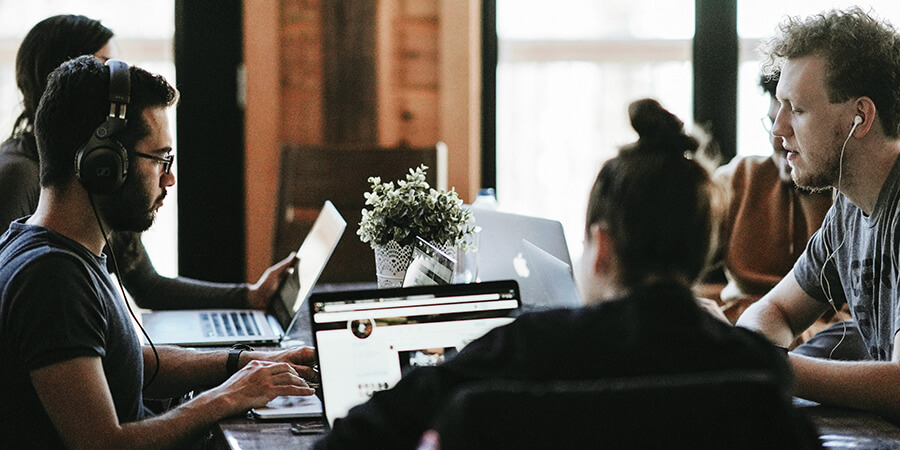 Group of people collaborating around a desk.