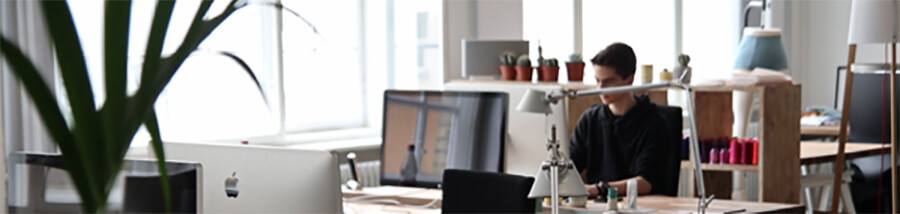 Lone worker sitting in an open plan office.