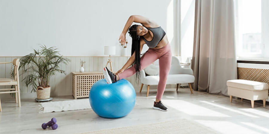 A person stretching on a blue exercise ball.